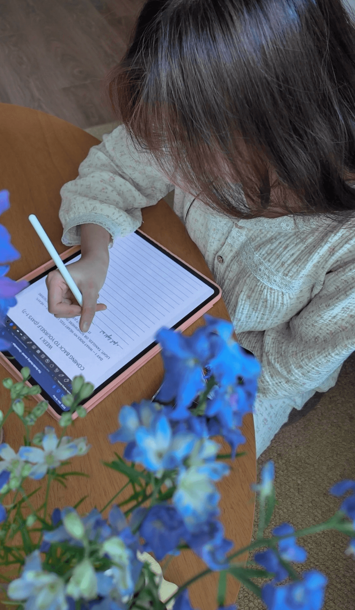 Cece journaling on iPad with blue flowers